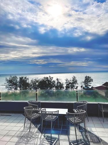 a patio with chairs and a table and a view of the ocean at Du Parc Mũi Né Resort - Sᴀɴᴅ ᴅᴜɴᴇ & ᴏᴄᴇᴀɴ ᴠɪᴇᴡ in Mui Ne