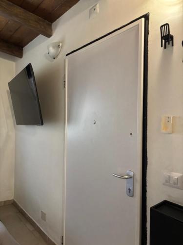 a white door with a television on the wall at Mambo House in Milan