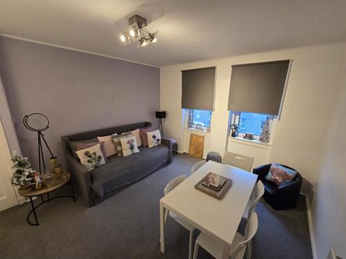 a living room with a couch and a table at Bespoke Tours Scotland Accommodation @ Morrison Street in Edinburgh