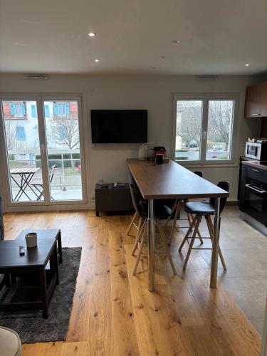 un salon avec une table et une cuisine dans l'établissement Coco Room Colmar, à Colmar