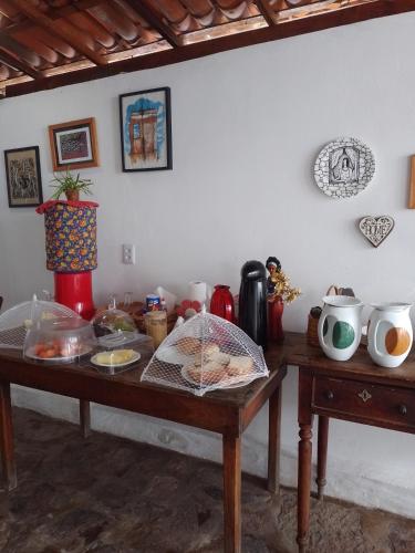 a wooden table with food on top of it at CASA TRILHAS DE IGATU - CHAPADA DIAMANTINA - BAHIA in Igatu