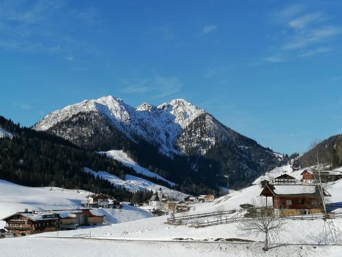 a snow covered mountain with a town in the foreground at Ferienwohnung Prent Wildschönau WILD023 by FeWo-Plan in Dorf