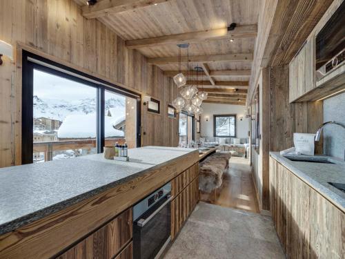 Il comprend une cuisine avec des murs en bois et une grande fenêtre. dans l'établissement Luxueux Penthouse Montagne – 4 Chambres, Parking, Wi-Fi - FR-1-641-19, à Tignes