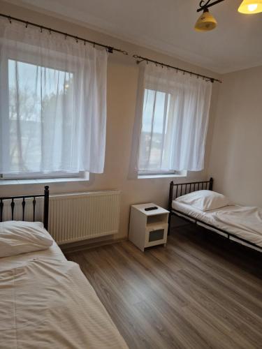 sypialnia z dwoma łóżkami i dwoma oknami w obiekcie Restauracja i Noclegi Pod Sikorką w mieście Kobior