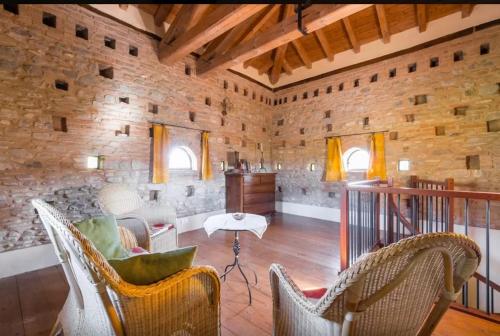 salon z krzesłami i kamienną ścianą w obiekcie Agriturismo Ca' Bertu' w mieście Zappolino