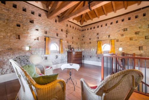 a living room with chairs and a stone wall at Agriturismo Ca' Bertu' in Zappolino