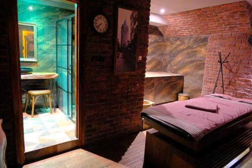 a room with a bed and a brick wall at Kayıbeyi Hotel & Restaurant in Bursa
