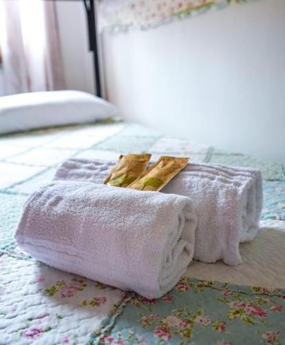 a pair of towels sitting on top of a bed at MAESTRALE B&B in Arbus