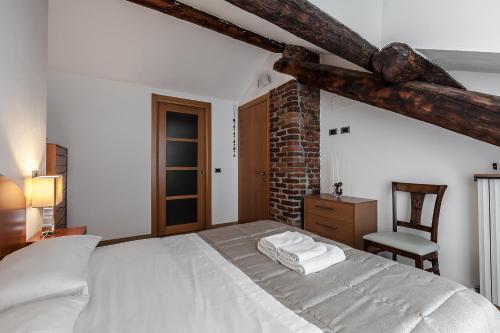 1 dormitorio con 1 cama blanca y 1 silla en MilanRentals - Palazzi Apartment, en Milán