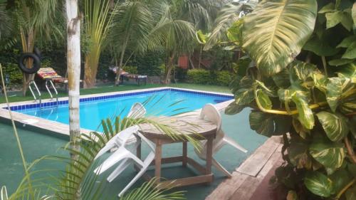 a swimming pool with a table and a chair next to it at Kindo Kicha Farmhouse in Moshi