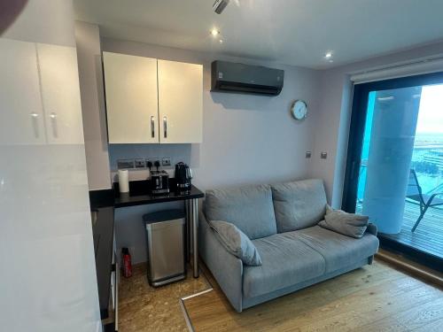 a living room with a couch and a kitchen at Seaside Serenity Oasis - High floor - Stunning Views in Gibraltar