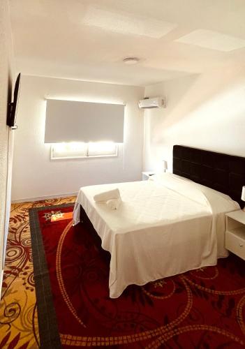 a bedroom with a white bed in a room at Hotel RICHMOND Punta del Este in Punta del Este