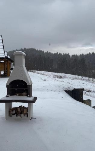 a stove sitting on top of a snow covered field at Domki 15 szczytów in Zawoja