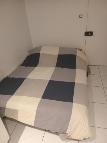 - une chambre avec une couette en noir et blanc sur un lit dans l'établissement Chambre proche centre ville monuments, à Paris