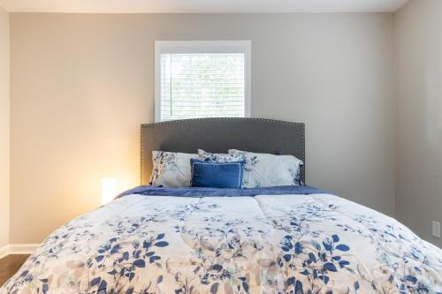 a bedroom with a bed with a blue and white comforter at Stylish and Cozy Retreat in Buford