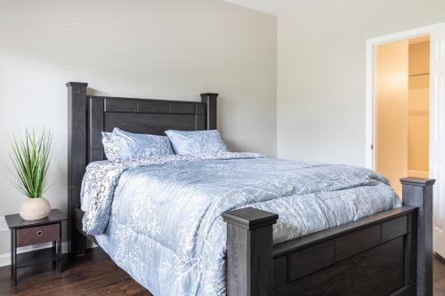 a bedroom with a bed with a blue comforter at Stylish and Cozy Retreat in Buford