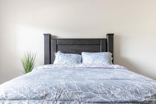 a bed with a blue comforter and pillows at Stylish and Cozy Retreat in Buford