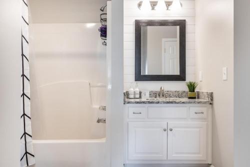 a white bathroom with a sink and a mirror at Stylish and Cozy Retreat in Buford