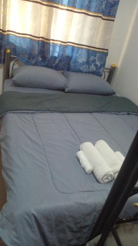 a bed with two white towels on it at บ้านแม่โฮมสเตย์ in Ban Pa Kwao