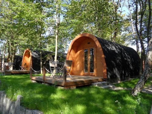 a small wooden cabin in a field of grass at 25 Premium Camping Pod "Sylt" in Silberstedt