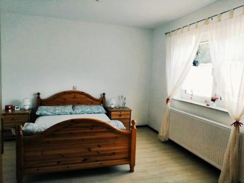 a bedroom with a wooden bed and a window at 76 qm Whg im EG Haus-Wohlfühloase vor der Haustür in Gladenbach