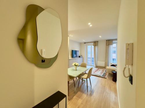Il comprend une cuisine et un salon avec une table et un miroir. dans l'établissement Très bel appartement entièrement rénové - 2mn Croisette, à Cannes