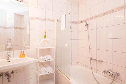 a bathroom with a shower and a sink at Werzer Strandcasino Hotel in Pörtschach am Wörthersee