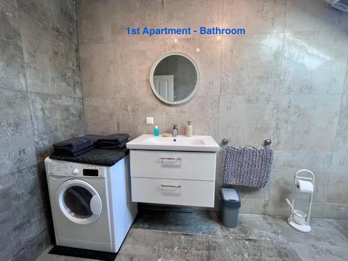 a bathroom with a washing machine and a sink at Cozy Apartment near Vienna Airport in Schwechat