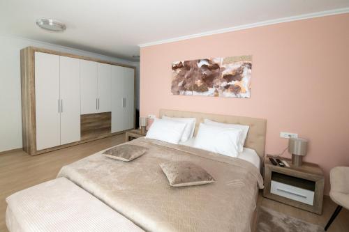 a bedroom with a large bed with white pillows at Villa Angela in Šmrika
