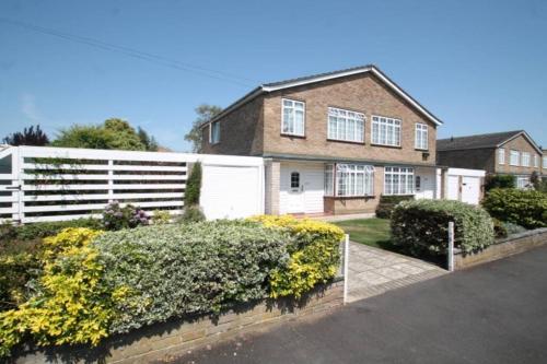 a house with a white fence and some bushes at Nicely decorated 3 bedroom house near Heathrow, London in London