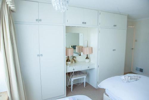 a bedroom with a bed and a desk with a mirror at Nicely decorated 3 bedroom house near Heathrow, London in London