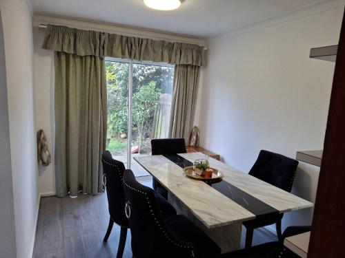 a dining room with a table and chairs and a window at Nicely decorated 3 bedroom house near Heathrow, London in London