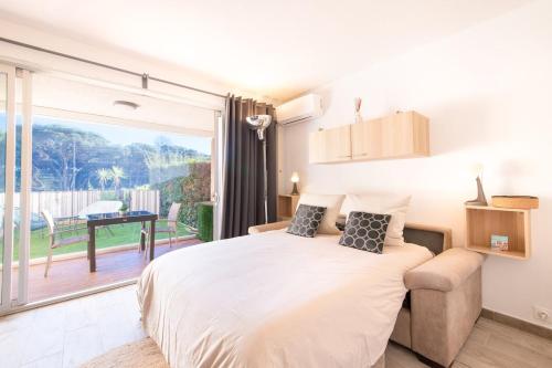 une chambre avec un grand lit et un balcon dans l'établissement Studio-cabine climatisé -4 pers- Proche de la mer, à Sainte-Maxime