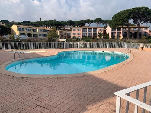 - une petite piscine dans une zone en briques avec des bâtiments dans l'établissement Studio-cabine climatisé -4 pers- Proche de la mer, à Sainte-Maxime