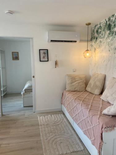 a bedroom with a bed with a pink blanket at Bánhiday H31 Beach house in Balatonakarattya