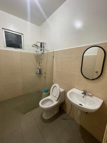 a bathroom with a sink and a toilet and a mirror at Bunga Home with swimming pool access in Lahad Datu