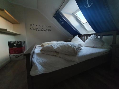 a bedroom with a bed with white sheets and a window at Ferienwohnung "Kombüse" in Sahrensdorf