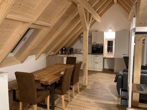 a kitchen and dining room with a wooden table and chairs at Schöne Dachwohnung mit 2 Schlafzimmern im Zentrum von Schwarzenberg - Erzgebirge in Schwarzenberg (Erzgebirge)