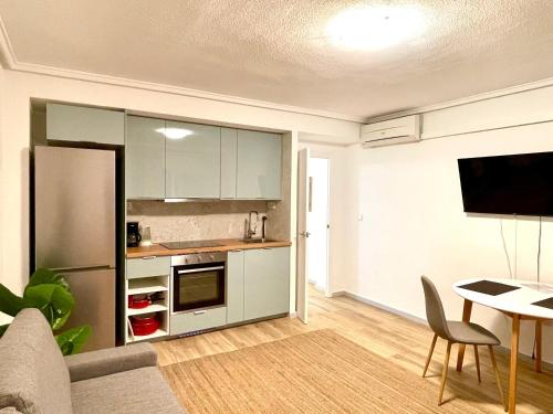kuchnia z lodówką i stołem w pokoju w obiekcie Portus apartment with pool w mieście Santa Pola