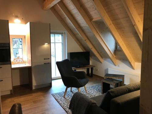 a living room with a couch and a chair at Schöne Dachwohnung mit 2 Schlafzimmern im Zentrum von Schwarzenberg - Erzgebirge in Schwarzenberg (Erzgebirge)
