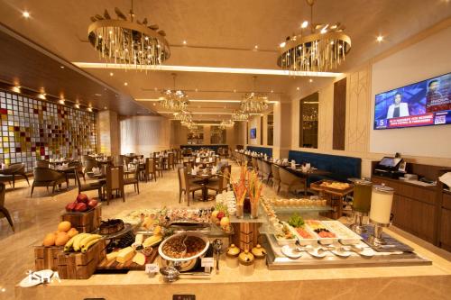 a restaurant with a buffet of food on a table at The Gaurs Sarovar Premiere in Ghaziabad