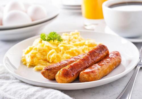 two sausages and scrambled eggs on a white plate at Bed and breakfast Jadran in Neum