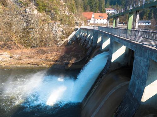 a bridge over a river with a waterfall at Ferienhaus Nr 8A2, Feriendorf Hagbügerl, Bayr Wald in Waldmünchen