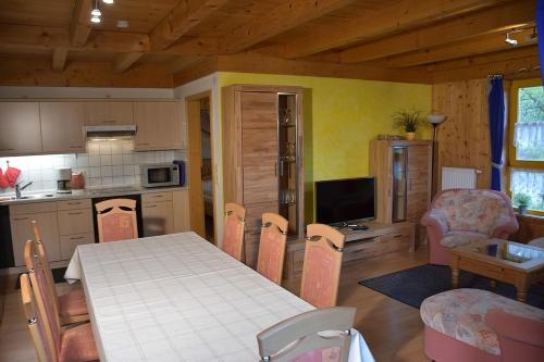 a kitchen and dining room with a table and chairs at Ferienhaus Nr 1C, Feriendorf Hagbügerl, Bayr Wald in Waldmünchen