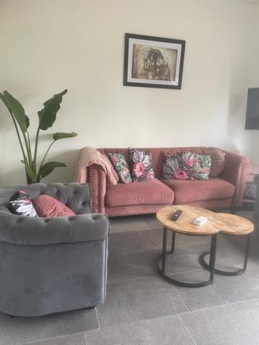 a living room with two couches and a coffee table at Guesthouse ML in Hillegom