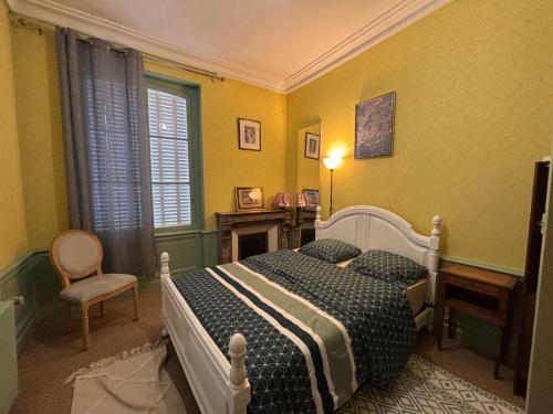 une chambre avec un lit et une chaise dans l'établissement Belle Maison de Maitre avec jardin, à Coulonces