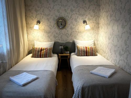 two twin beds in a room with two towels at Apartamenty 72 - Agroturystyka in Wola Pękoszewska