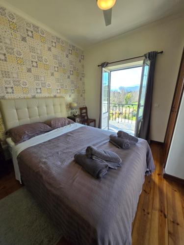 a bedroom with a large bed with towels on it at Quinta do Rio Alva and Glamping Lodges in Mouronho