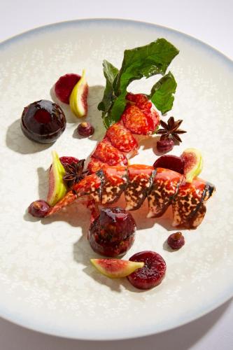 a white plate of food with fruit and vegetables at Domaine les Crayères in Reims