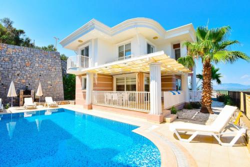 a villa with a swimming pool and a house at Villa Maya The Royal Links Sarigerme in Sarigerme